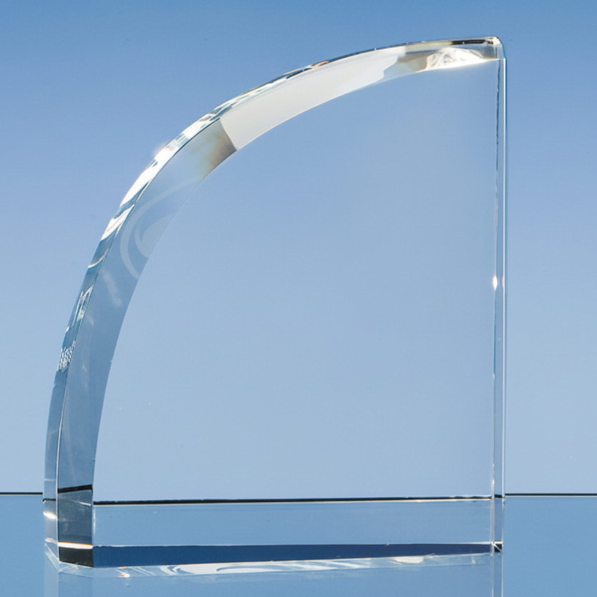 Clear glass arch award on a reflective surface with a blue gradient background