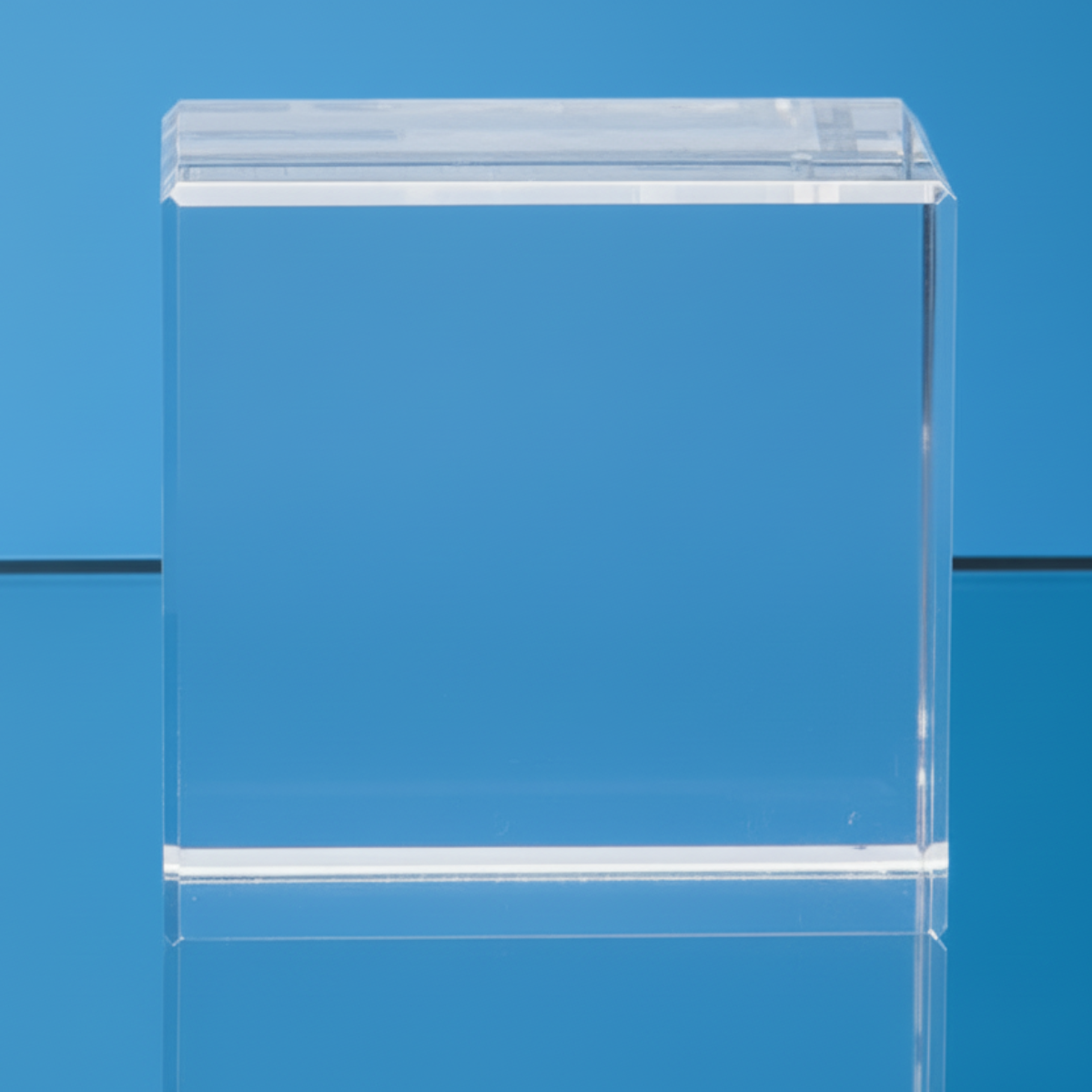 Clear GLASS block on a reflective surface with a blue background